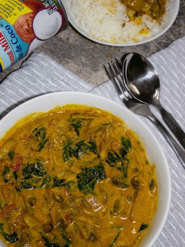Creamy mushroom spinach curry with coconut milk served with rice.